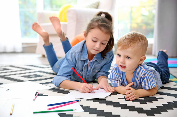 小さな女の子と自宅の床に描く少年 - 写真・画像