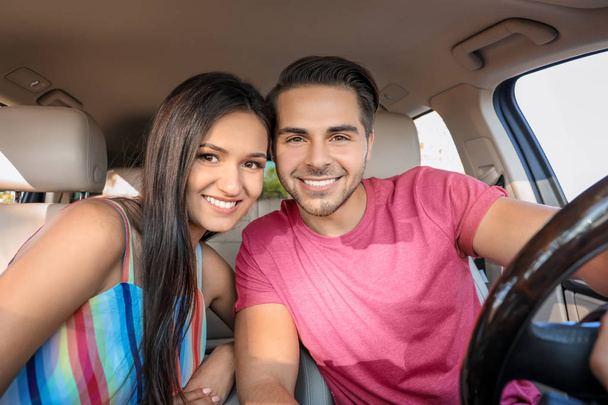 Beautiful young couple in car - 写真・画像