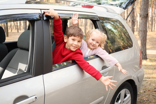 Adorable little children leaning out of car window - Photo, Image