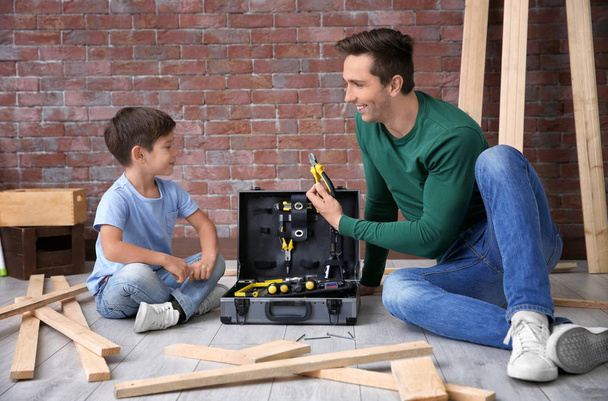 Father showing his little son different tools in workshop - Φωτογραφία, εικόνα