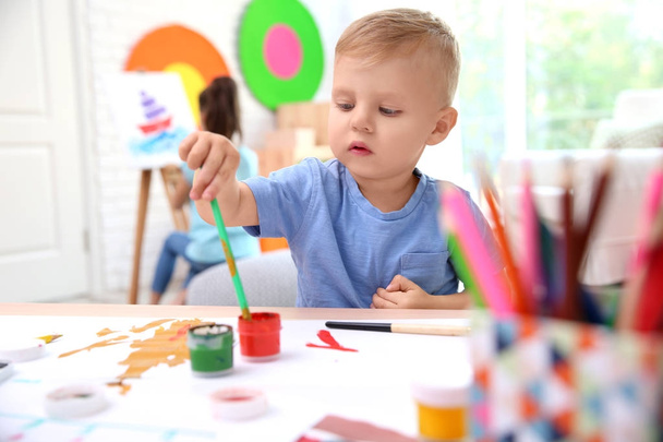 Маленький мальчик и размытая девочка рисуют в помещении
 - Фото, изображение