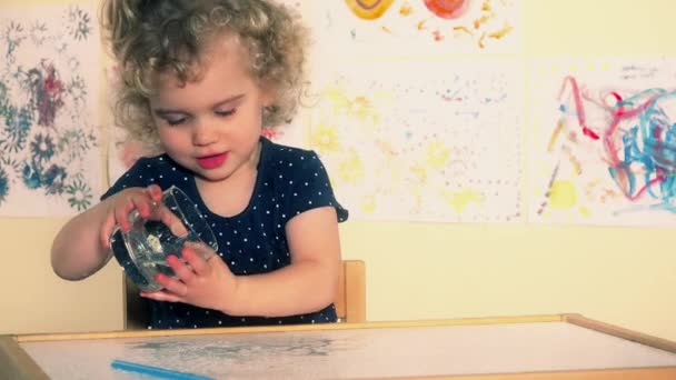 Criança infantil curiosa despeje água na mesa. Garoto molhado excitado brincando com água
 - Filmagem, Vídeo
