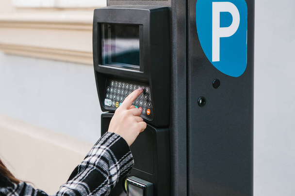 Una moderna terminal para pagar el aparcamiento. La persona presiona los botones y paga por el estacionamiento. Tecnología moderna en la vida cotidiana
. - Foto, Imagen