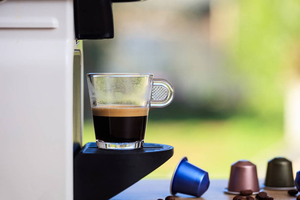Máquina de café expresso em uma mesa de madeira, fundo borrão, espaço para texto
 - Foto, Imagem