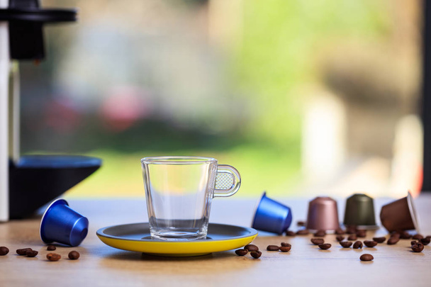空のコーヒー カップ、エスプレッソのカプセルと詳細クローズ アップ ビューのぼかし背景のコーヒー豆 - 写真・画像