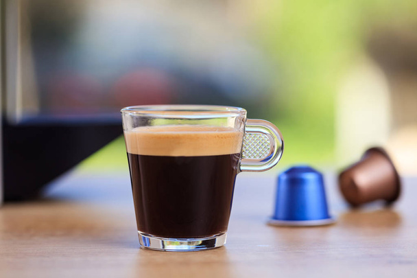 Espresso cup and coffee capsules on blur background, Closeup view with details - Photo, Image