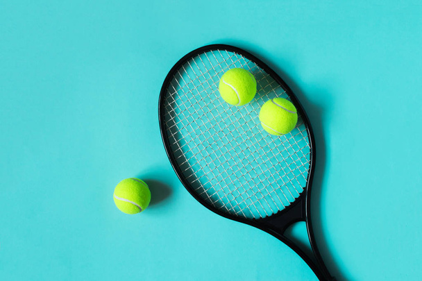 Tennis balls and racket on blue background. Sport equipment. Flat lay. - Photo, Image