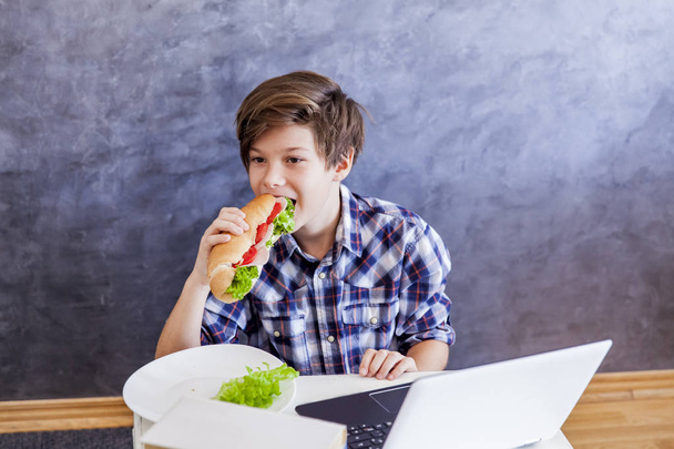 Ritratto di adolescente mangia un panino e web-surf
 - Foto, immagini