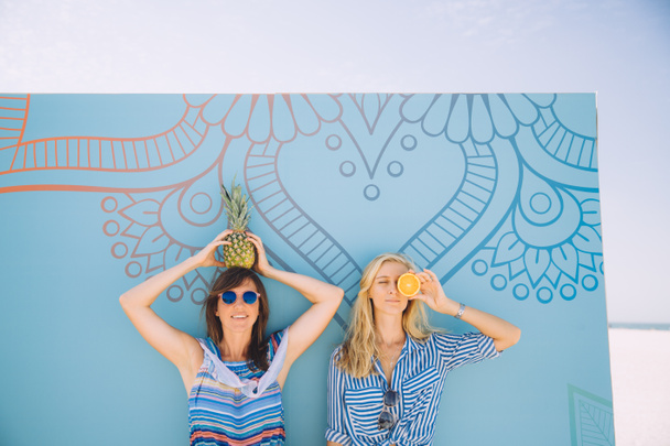 due giovani donne felici in posa con frutti tropicali
 - Foto, immagini