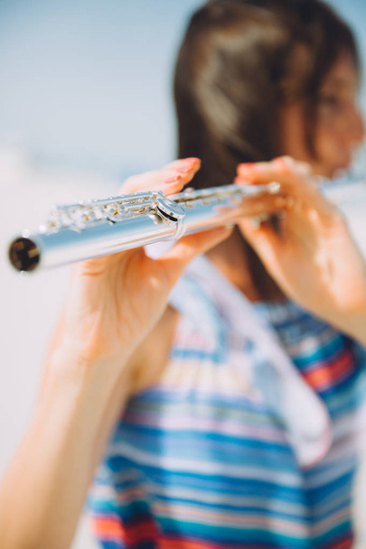 young beautiful woman playing the flute at beach - Photo, Image