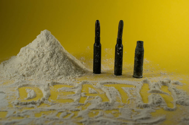 Droga de la cocaína con balas en un fondo amarillo
 - Foto, imagen