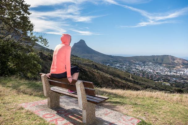 жінка в спортивному одязі сиділа з видом на мис місто
 - Фото, зображення