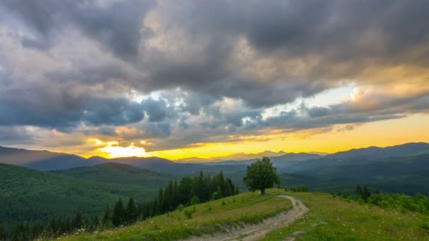 Sunset Sky in the Mountains with a Lone Tree and Dirt Road in the Foreground and Clouds in the Background. Timelapse.  - Footage, Video