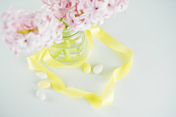 Jacinto de flores frescas en jarrón de vidrio con cinta amarilla. Vista superior
 - Foto, imagen