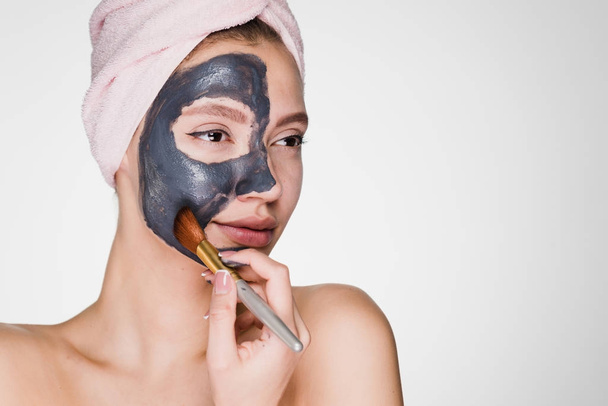 a young girl puts on her face a black mask - Foto, Imagen