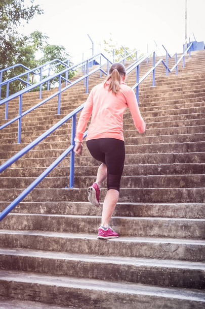 atlética mujer corriendo por un tramo de escaleras
 - Foto, Imagen