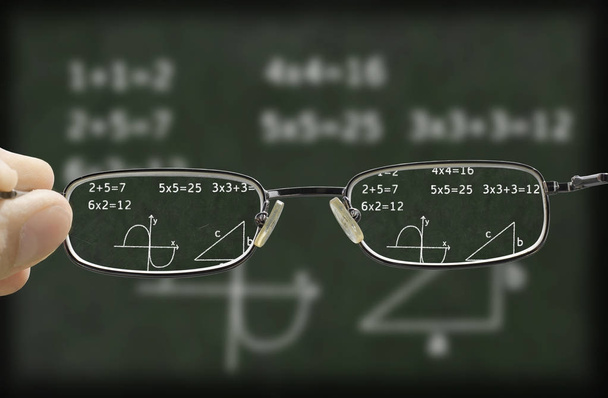 расплывчатое зрение зеленой доски с математическим расчетом на ней скорректировано очками
 - Фото, изображение