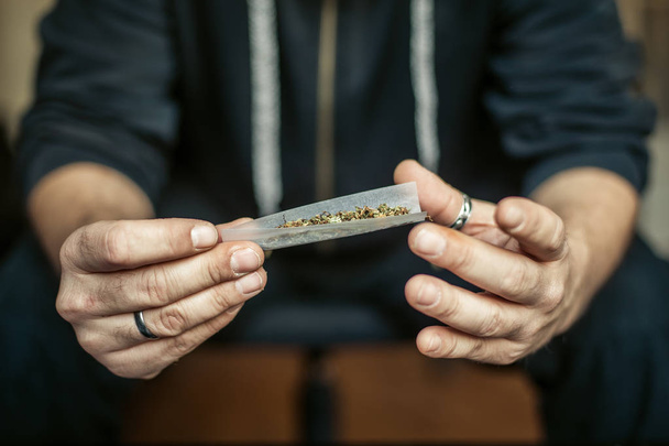 Preparing and rolling marijuana cannabis joint. Drugs narcotic c - Valokuva, kuva