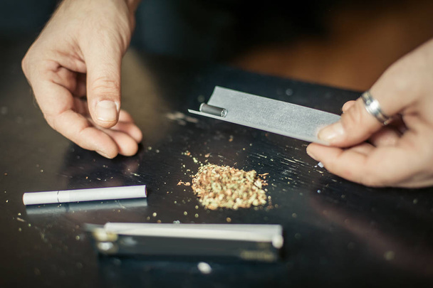 Preparing and rolling marijuana cannabis joint. Drugs narcotic c - Фото, изображение
