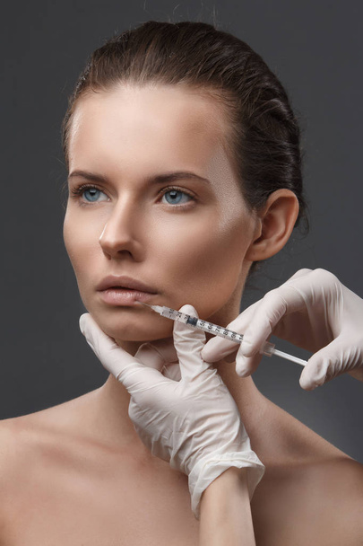 Portrait of young Caucasian woman getting cosmetic injection - Fotoğraf, Görsel