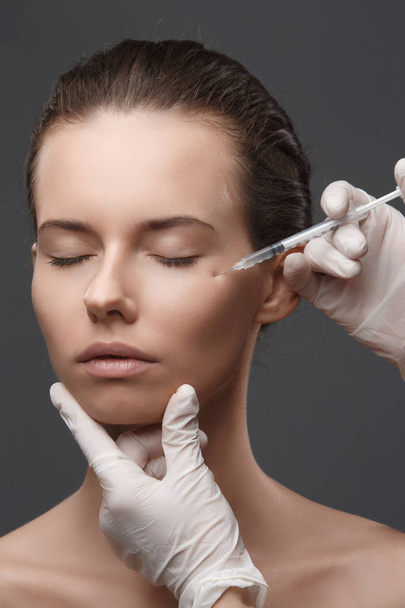 Portrait of young Caucasian woman getting cosmetic injection - Zdjęcie, obraz