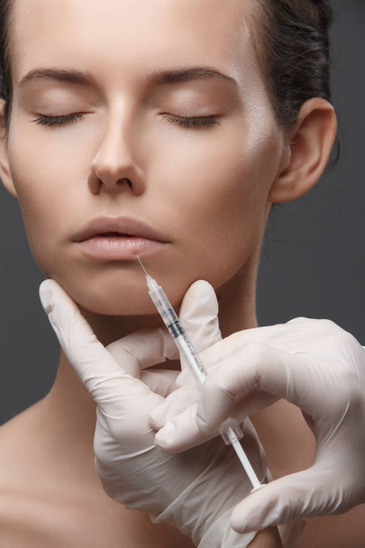 Portrait of young Caucasian woman getting cosmetic injection - Foto, imagen