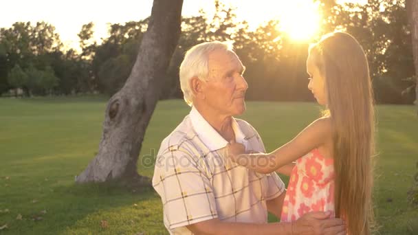 Büyükbaba ve küçük kız açık havada konuşuyor. - Video, Çekim