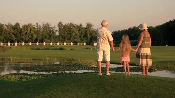 Παππούδες και γιαγιάδες με την εγγονή, το περπάτημα κοντά στο νερό. - Πλάνα, βίντεο