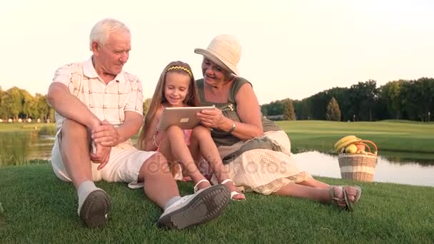 Девушка с бабушкой и дедушкой держит планшет
. - Кадры, видео