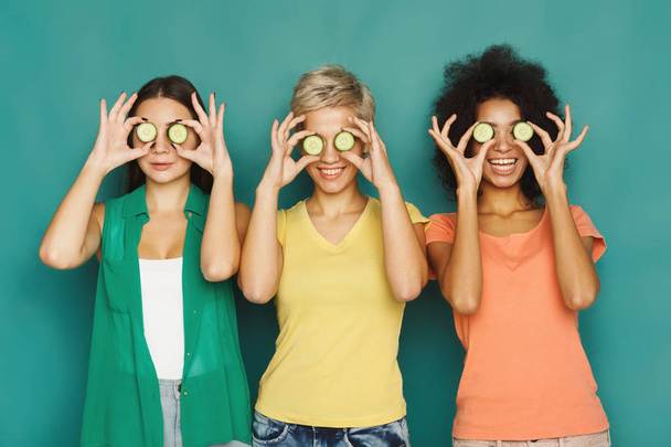 три красиві дівчата, що прикривають очі шматочками огірка
 - Фото, зображення