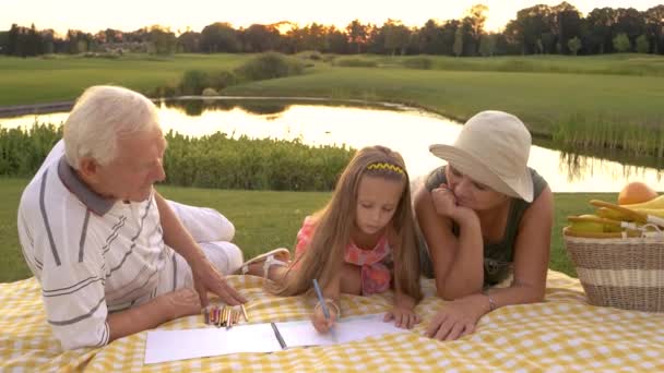 Kleines Mädchen zeichnet mit Großeltern. - Filmmaterial, Video