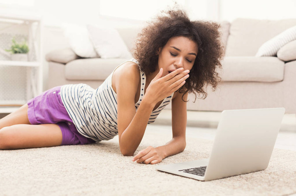 Genç kız yerde yatarken dizüstü bilgisayar ile yorgun - Fotoğraf, Görsel