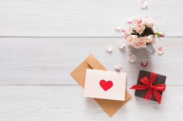 Valentine background pink rose flowers bouquet petals, gift boxes, handmade greeting card with hearts on white rustic wood - 写真・画像