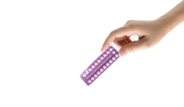 Vrouw hand nemen van geboortebeperking pillen. Aziatische volwassen vrouw pack van anticonceptiepillen geïsoleerd op een witte achtergrond met uitknippad te houden. Het kiezen van gezinsplanning met geboortenbeperkingspillen concept - Foto, afbeelding