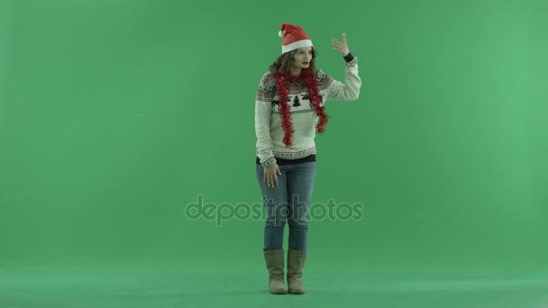 Belle jeune femme en chapeau de Noël invite quelqu'un à venir avec geste de la main, clé chromatique sur fond
 - Séquence, vidéo