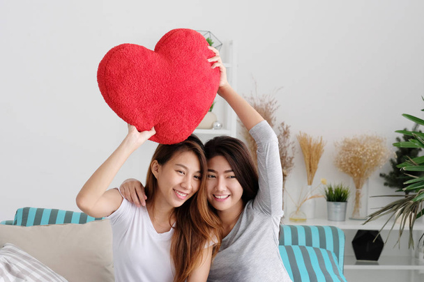 ЛГБТ, молодые милые азиатские лесбиянки, держащие в руках красную иву в форме сердца
 - Фото, изображение