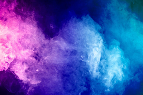 Blue, red, pink abstract cloud of smoke pattern on a black isolated background - Photo, Image