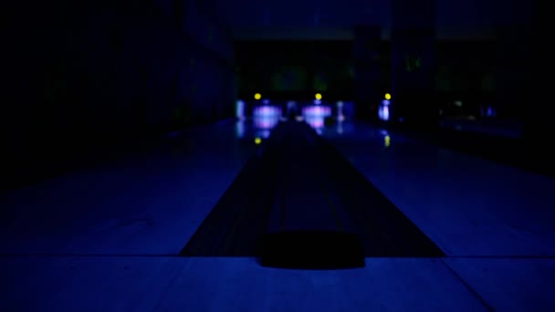 No clube de jogo para bowling, os jogadores em dois caminhos jogam bolas nos pinos. Profundidade superficial de abrasão. foco em primeiro plano
. - Filmagem, Vídeo