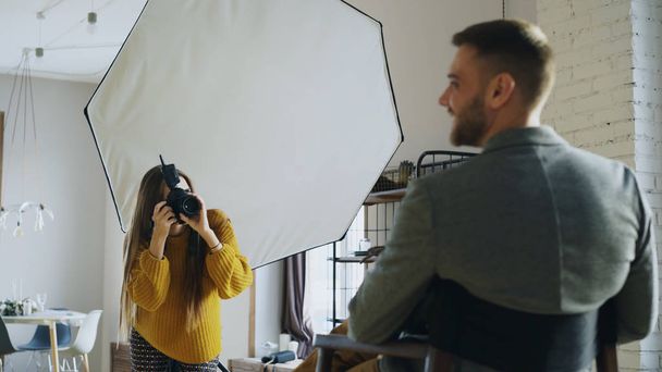 Professional photographer woman taking photo of businessman model girl with digital camera in studio - Foto, immagini