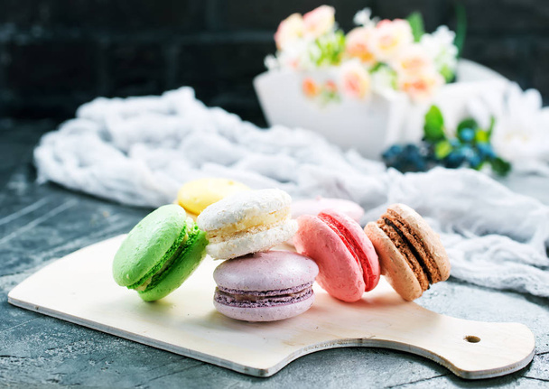 color macaroons on board and on a table - Foto, Bild