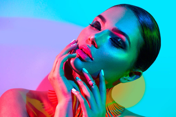 Fashion model in colorful bright lights with trendy make-up - Fotoğraf, Görsel
