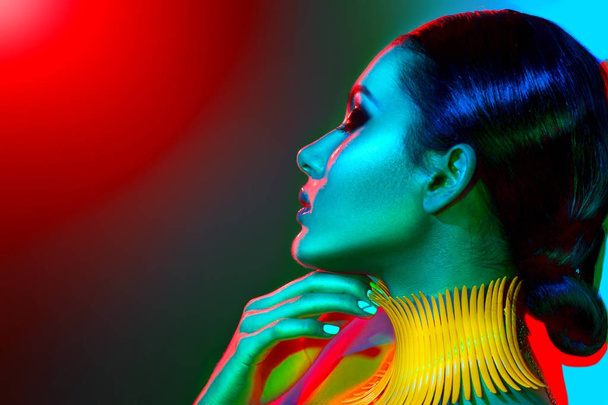 Fashion model in colorful bright lights with trendy make-up - Foto, afbeelding