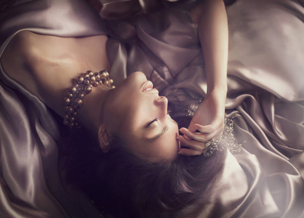 brunette woman sleeping on silk fabrics - Foto, Imagem