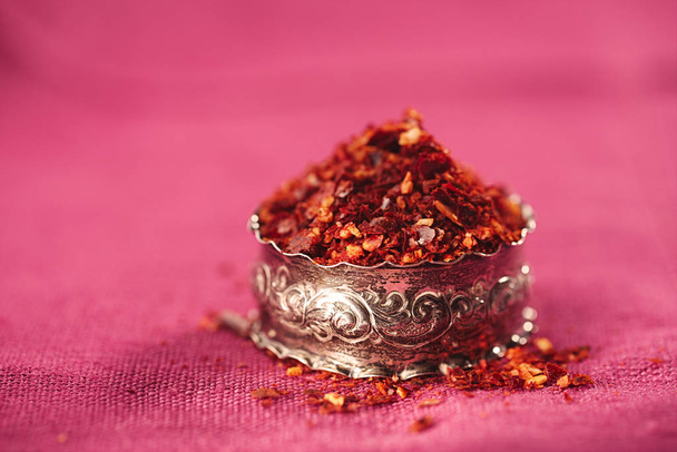 pila de mezcla de especias harissa en un tazón de metal pequeño sobre tela rosa, mezcla tradicional de chile rojo marroquí
 - Foto, imagen