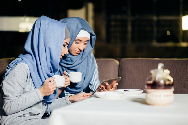 pretty muslim woman use tablet in cafe - Foto, afbeelding