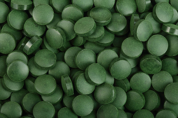 hoop Spirulina tabletten algen voedingssupplement als achtergrond dicht omhoog bovenaanzicht. Plat leggen - Foto, afbeelding