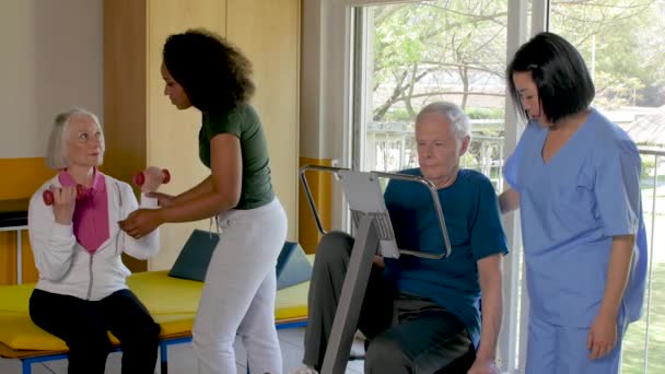 Starších lidí v rehabilitační klinice dělat gymnastiku s pomocí sester - Záběry, video