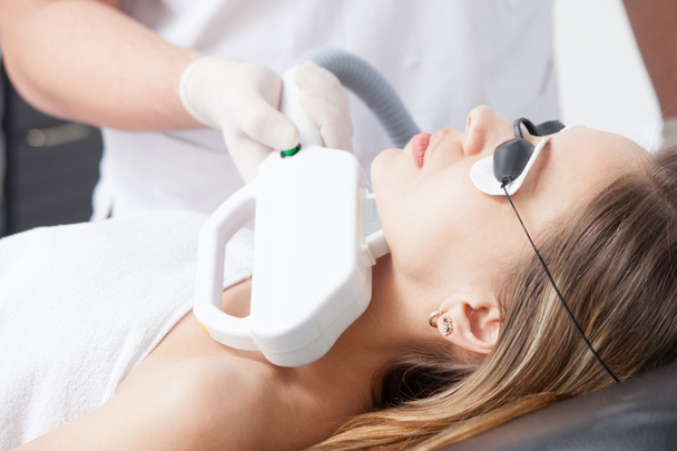 vrouw tijdens gezicht lasertherapie in cosmetica  - Foto, afbeelding