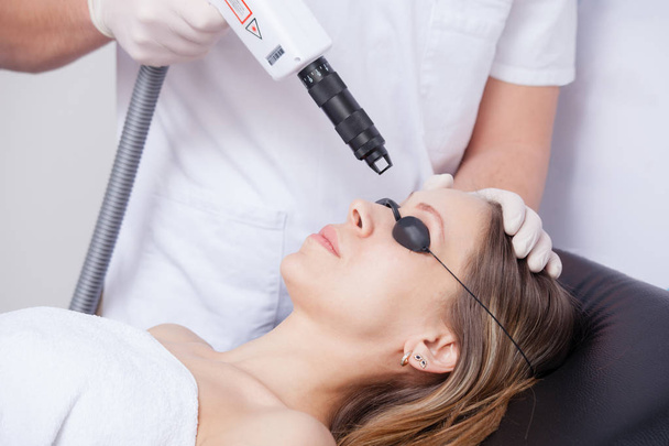 mujer durante la terapia con láser facial en cosméticos
  - Foto, imagen