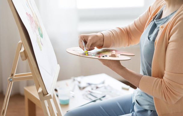 artist applying paint to palette at art studio - Photo, image